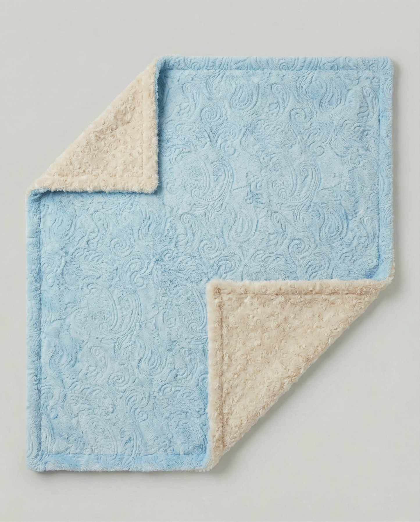 Blue and beige textured blanket on a light gray background