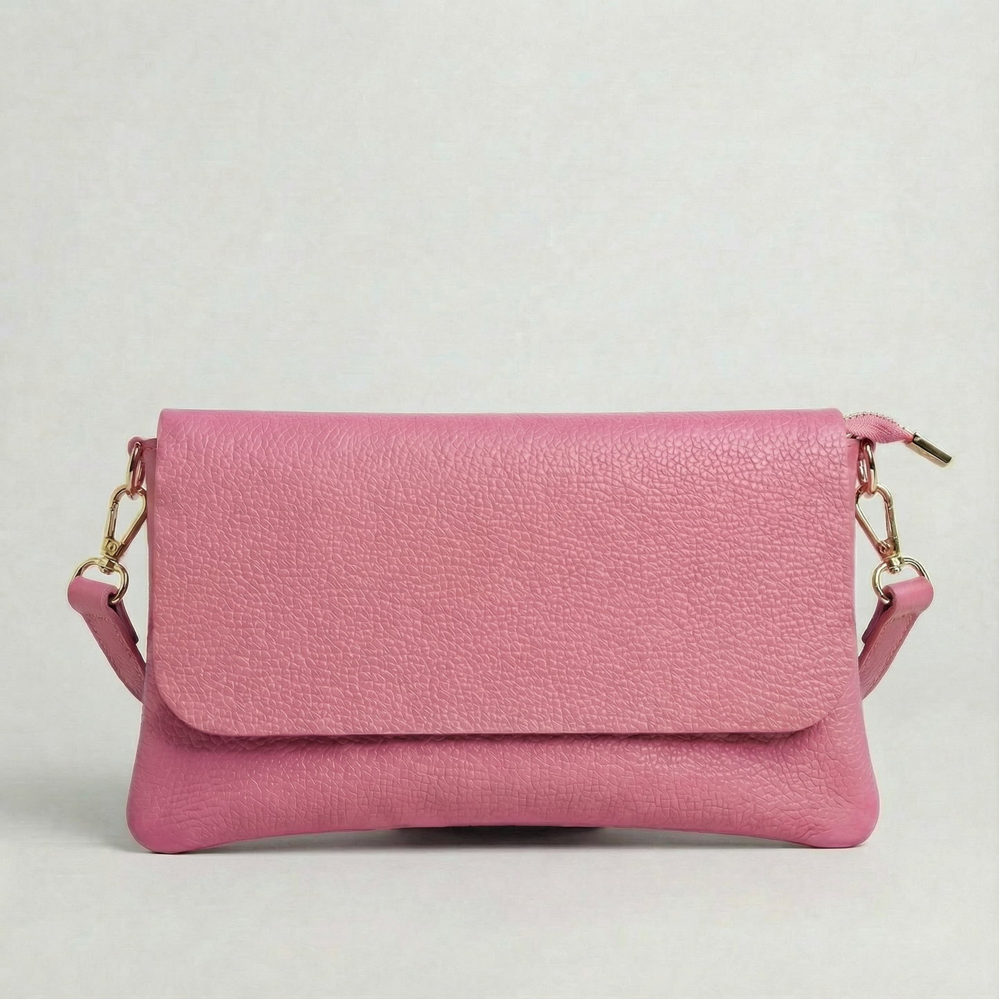 Barbie Pink pebble leather crossbody bag with a matching color adjustable strap, displayed on a light gray background.