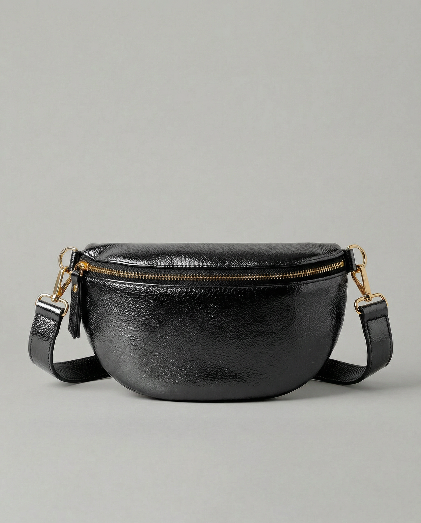 Metallic leather fanny bag in black with adjustable strap and sleek, compact silhouette designed for hands‑free everyday wear.