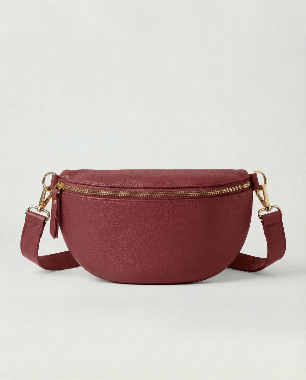 Cranberry pebble leather fanny bag with adjustable strap and compact, hands‑free design.