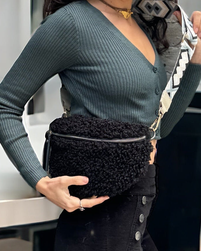 Black teddy fabric fanny bag with genuine leather accents, adjustable matching leather strap, and zip closure, made in Italy.