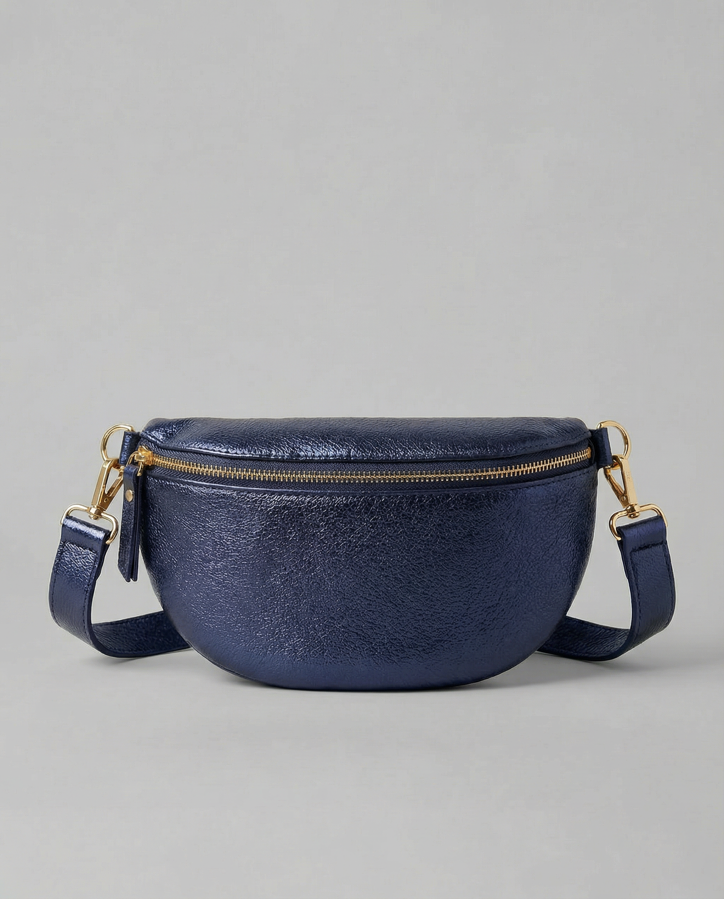 Metallic leather fanny bag in indigo with adjustable strap and sleek, compact silhouette designed for hands‑free everyday wear.