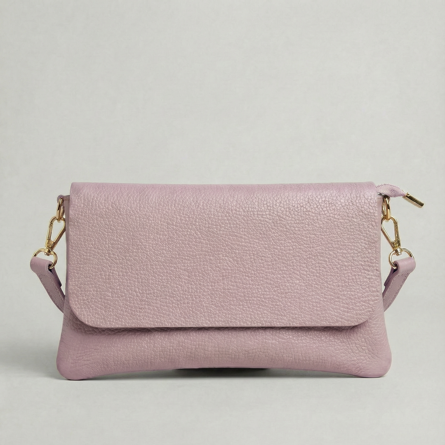 Lilac pebble leather crossbody bag with a matching color adjustable strap, displayed on a light gray background.