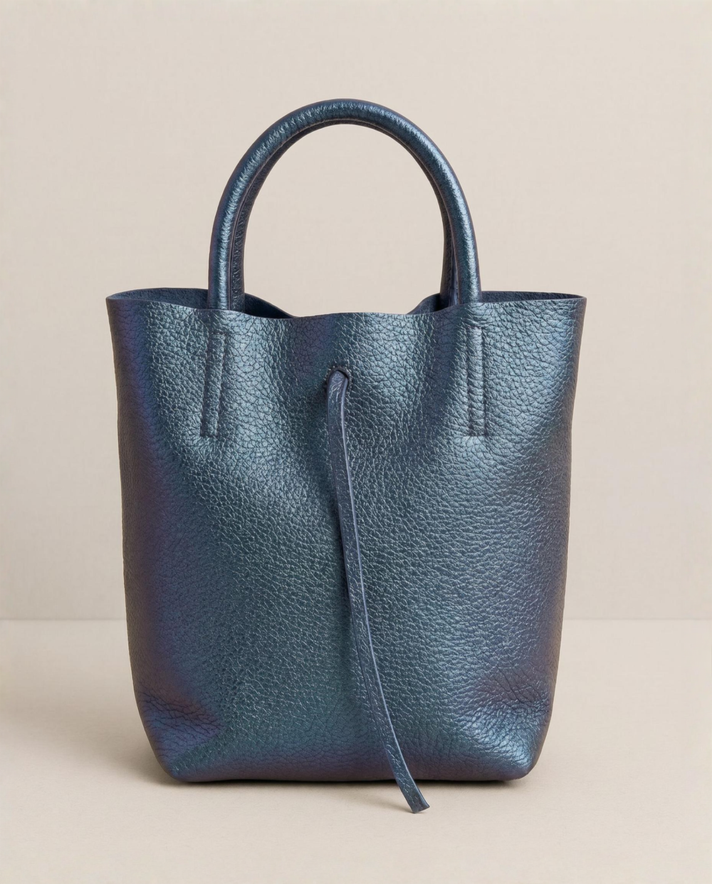 Mini tote in metallic denim leather with structured silhouette and top handles, sleek and compact design.