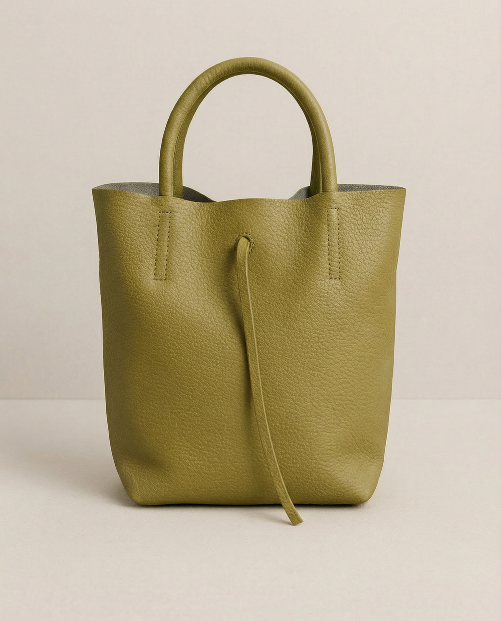 Chartreuse pebble leather mini tote with structured silhouette, detachable crossbody strap, compact interior, and genuine Italian craftsmanship.