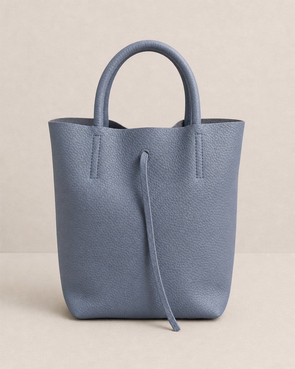 Denim pebble leather mini tote with structured silhouette, detachable crossbody strap, compact interior, and genuine Italian craftsmanship.