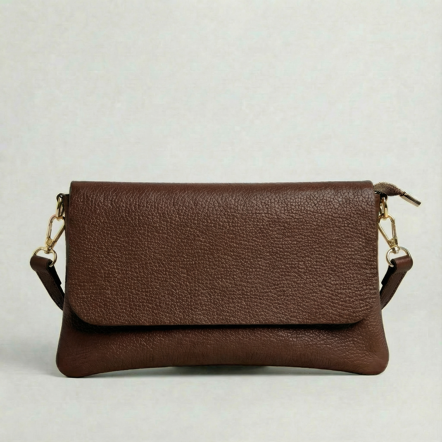Chocolate pebble leather crossbody bag with a matching color adjustable strap, displayed on a light gray background.