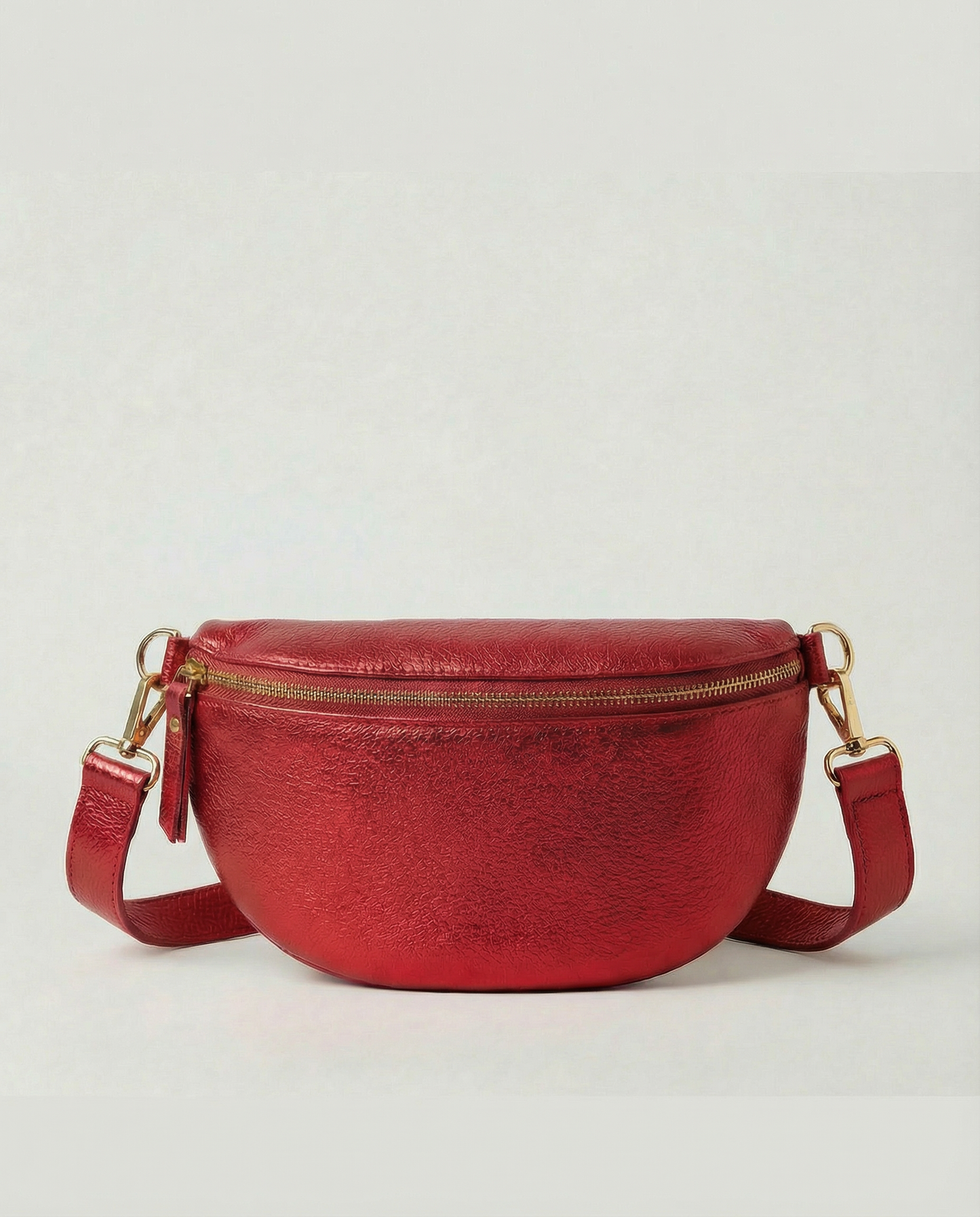 Metallic leather fanny bag in red with adjustable strap and sleek, compact silhouette designed for hands‑free everyday wear.