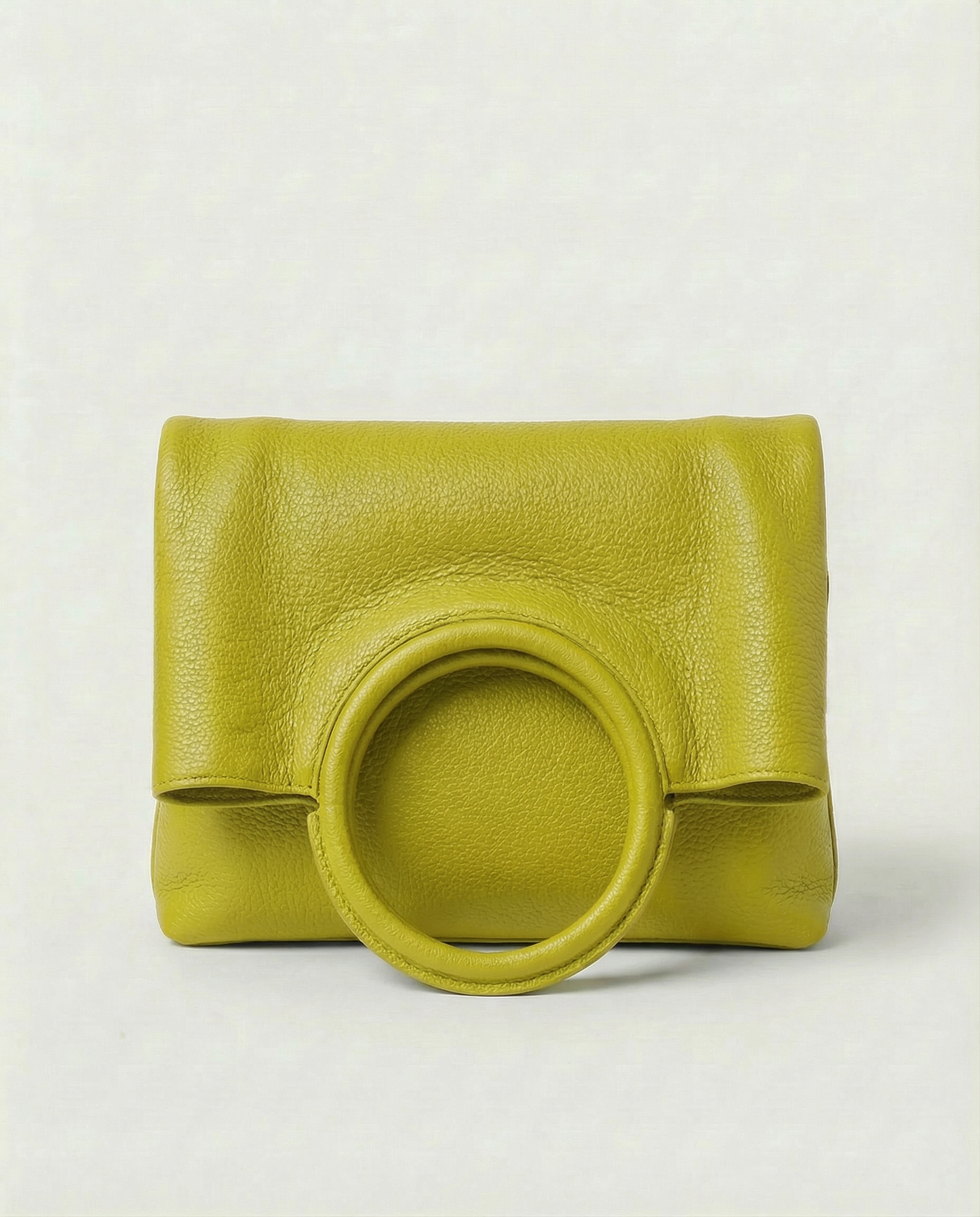 Ring Bag in pebble leather chartreuse with circular ring handle and structured silhouette.