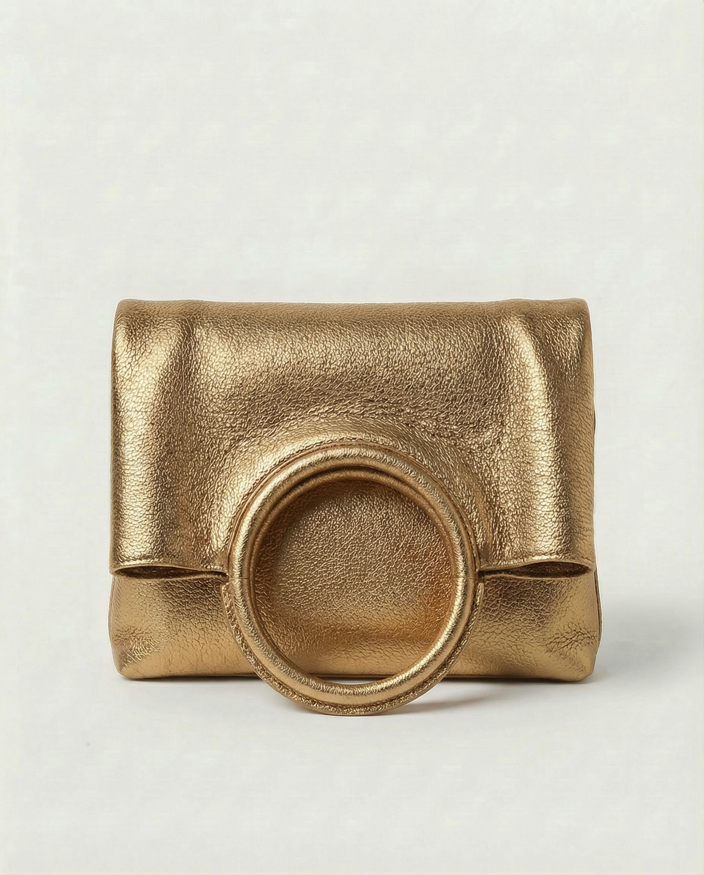 Metallic Antique Gold leather ring bag with circular top handle and structured silhouette, sleek and modern design.