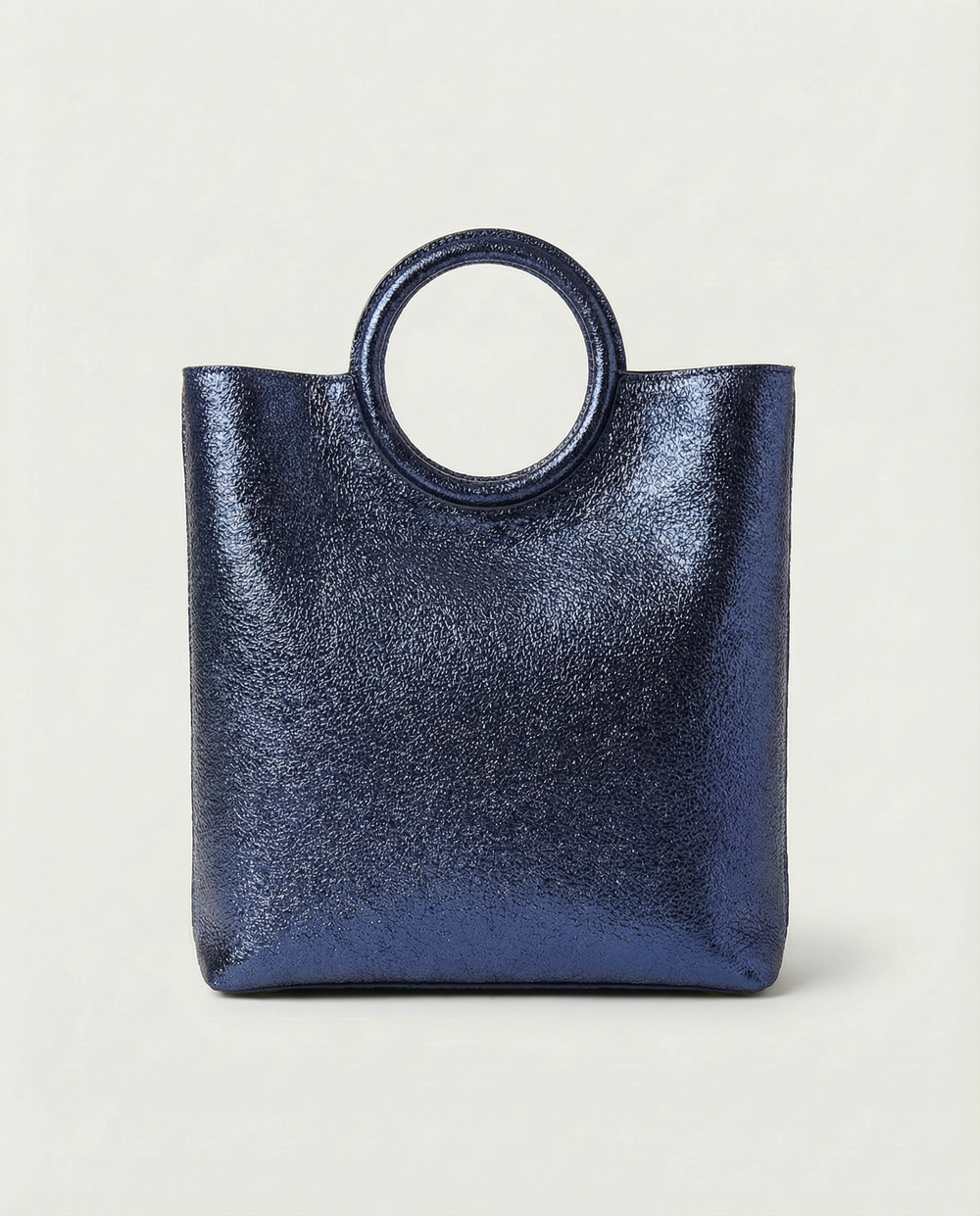 Metallic indigo leather ring bag with circular top handle and structured silhouette, sleek and modern design.