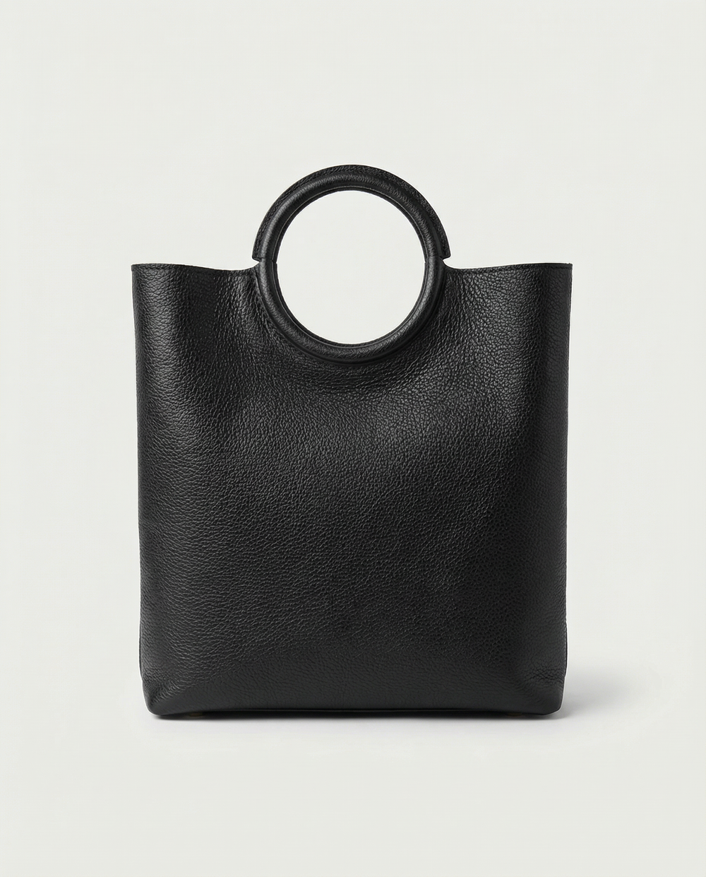 Ring Bag in pebble leather black with circular ring handle and structured silhouette.