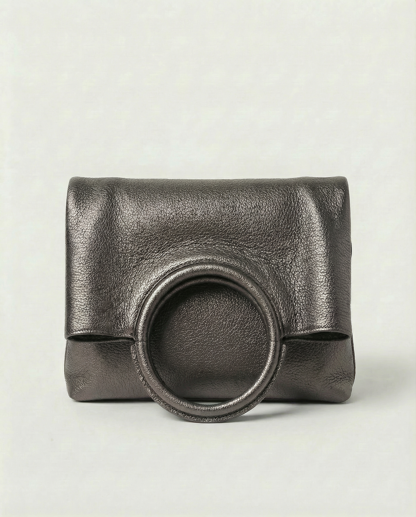 Metallic pewter leather ring bag with circular top handle and structured silhouette, sleek and modern design.