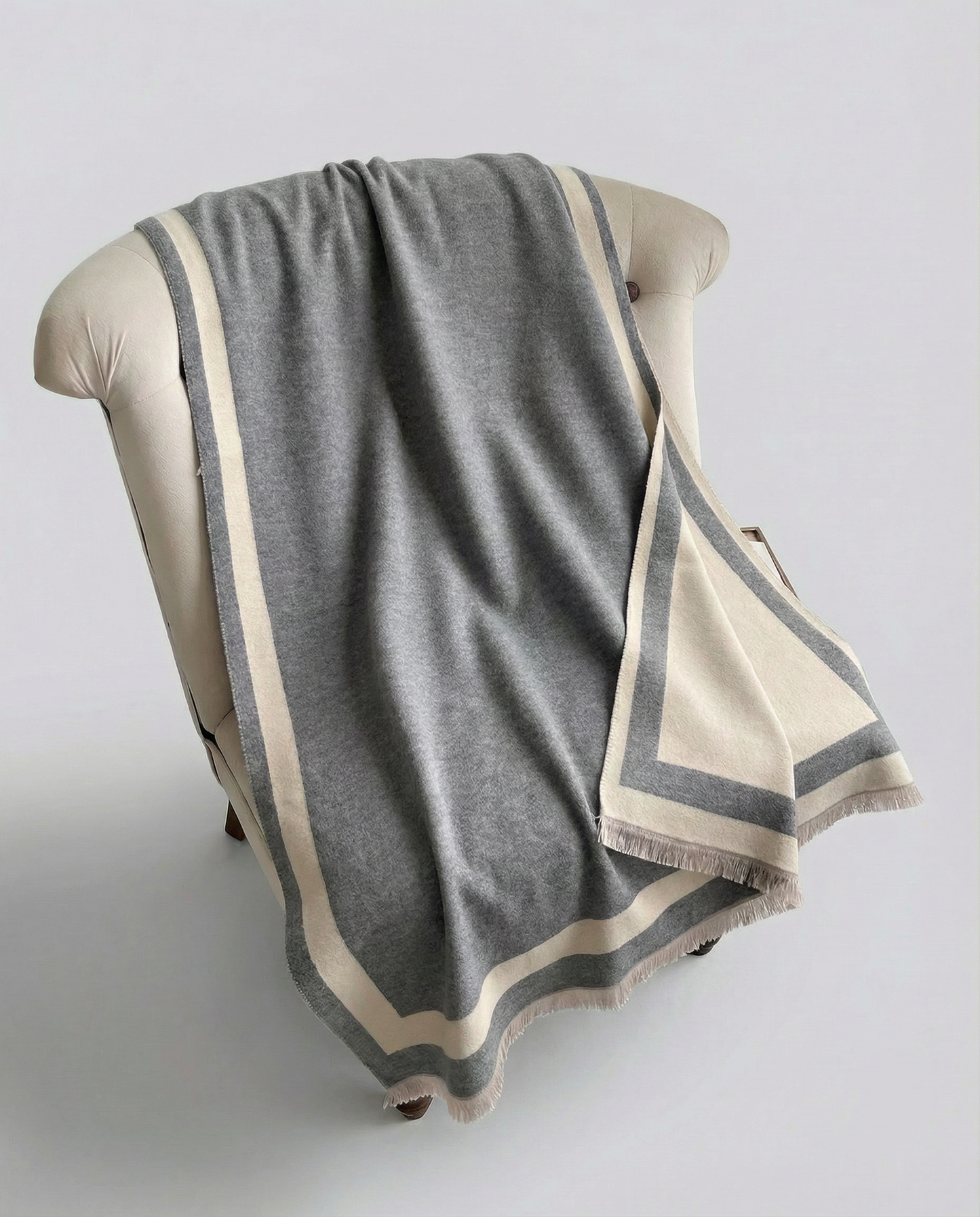 Gray and beige striped wrap draped over a chair on a light gray background
