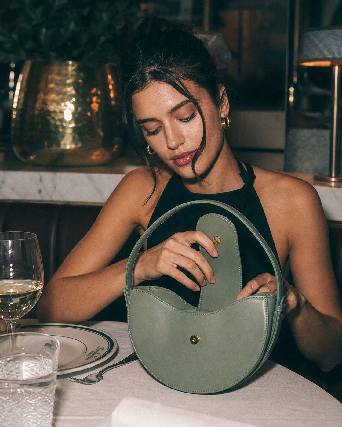 Woman carrying the Tourance Sorella circle bag in Verde Salvia