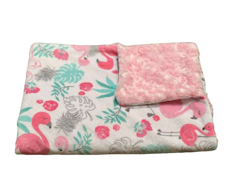Folded flamingo design blanket on a light background