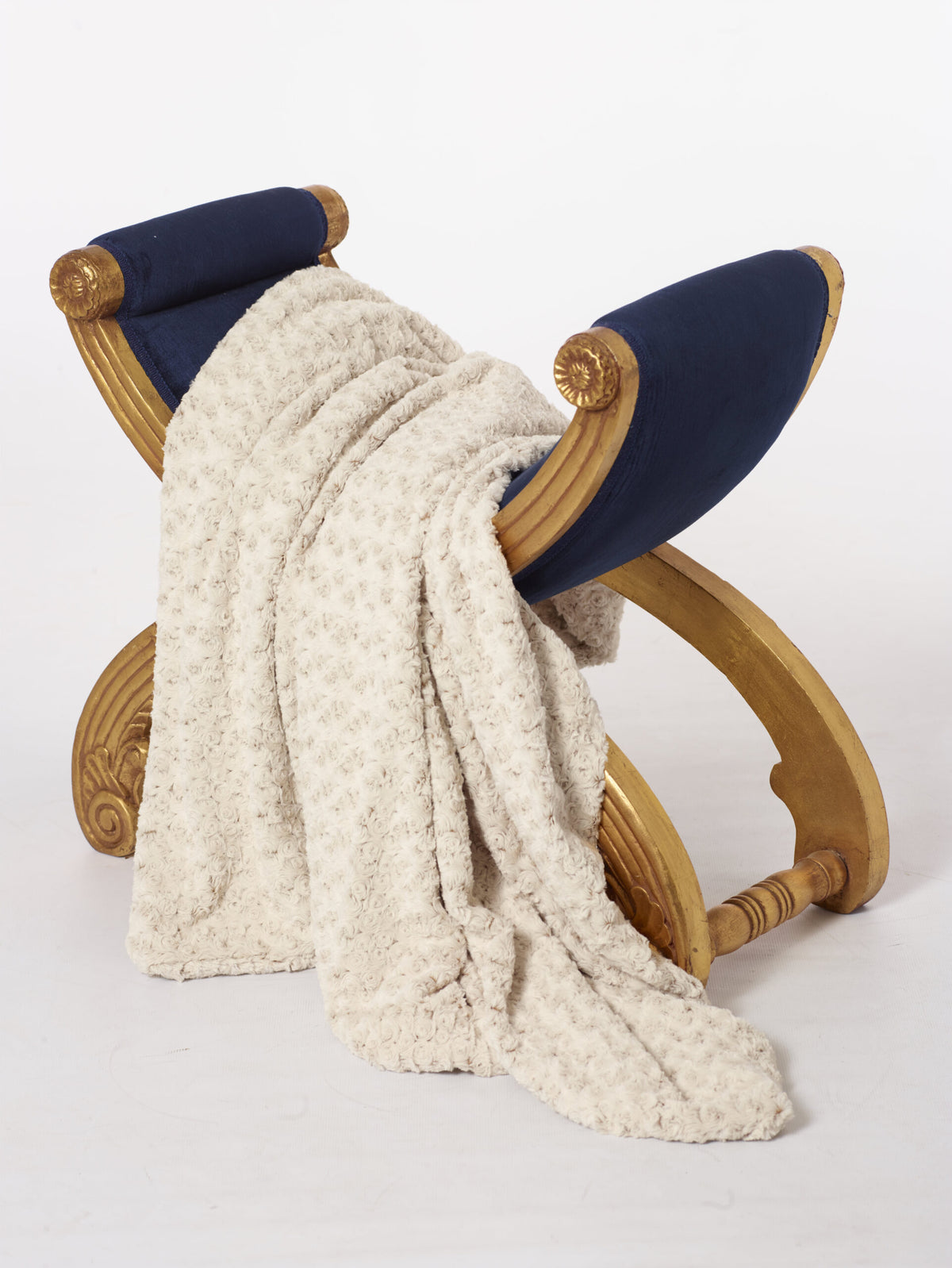 Rosebud Duotone Throw in Cream & Sahara on display stool