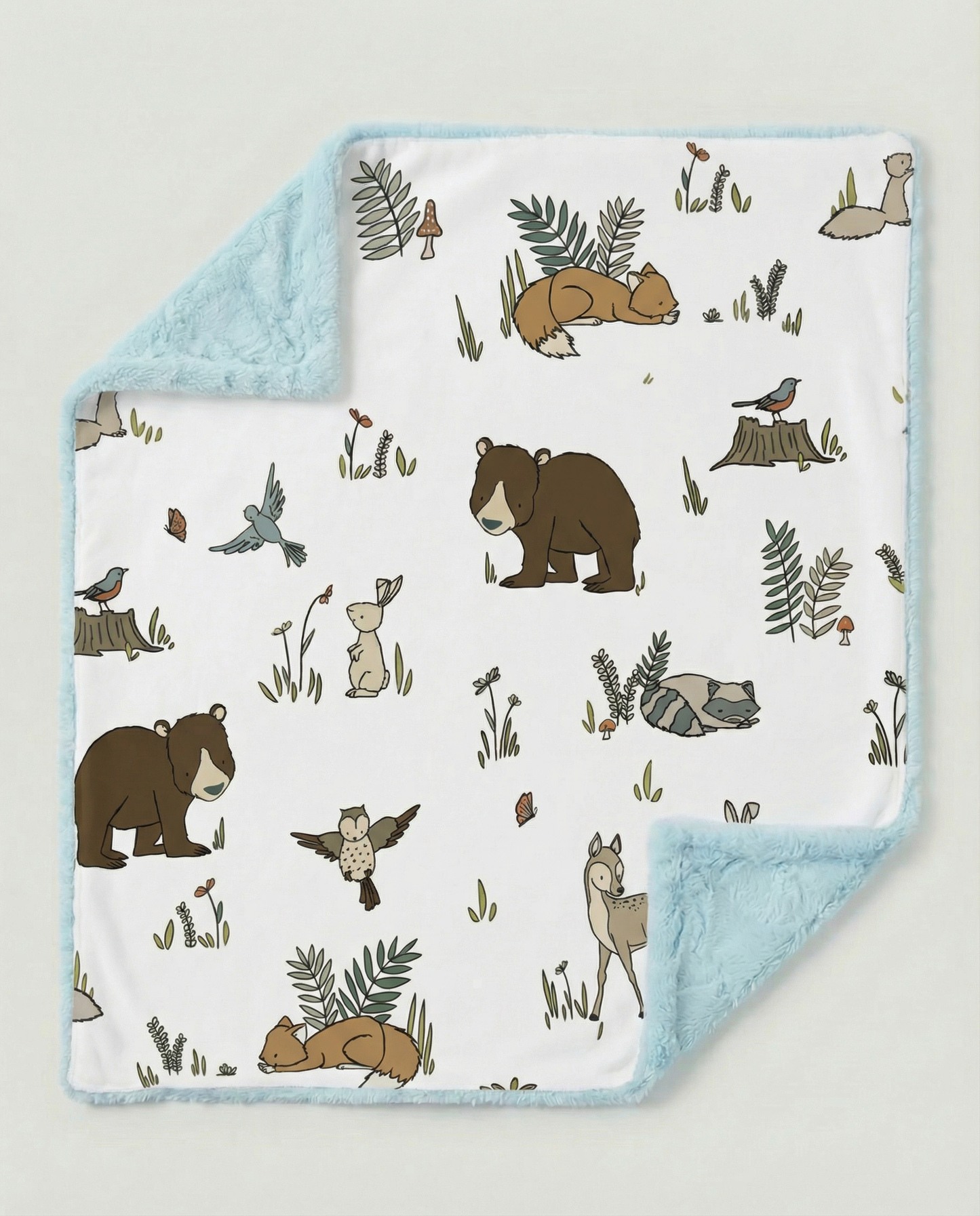Baby blanket with forest animal pattern on a light gray background