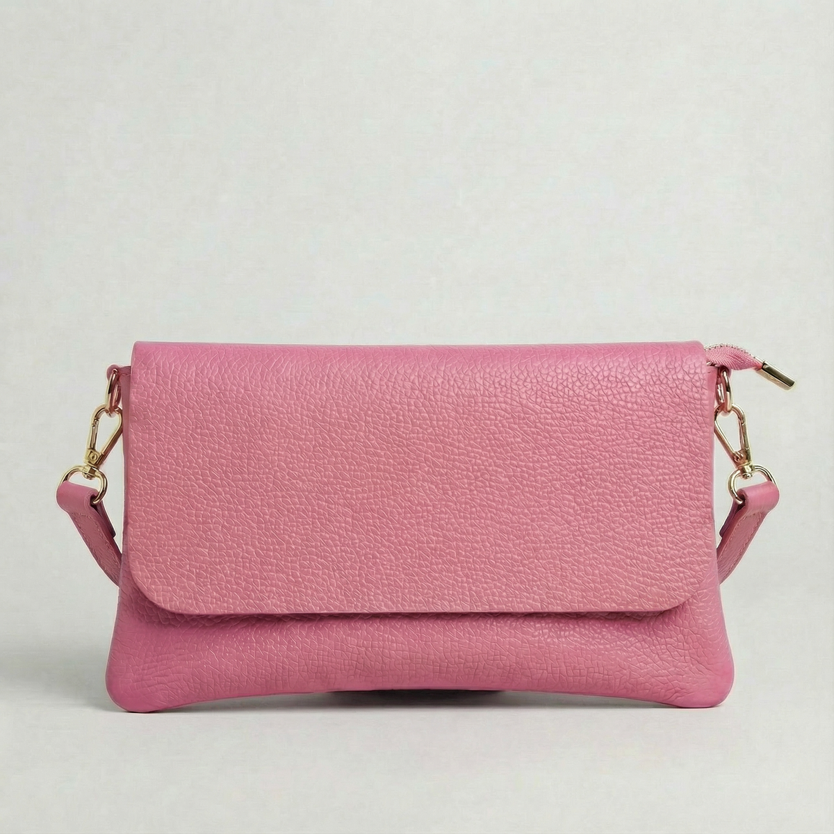 Barbie Pink pebble leather crossbody bag with a matching color adjustable strap, displayed on a light gray background.