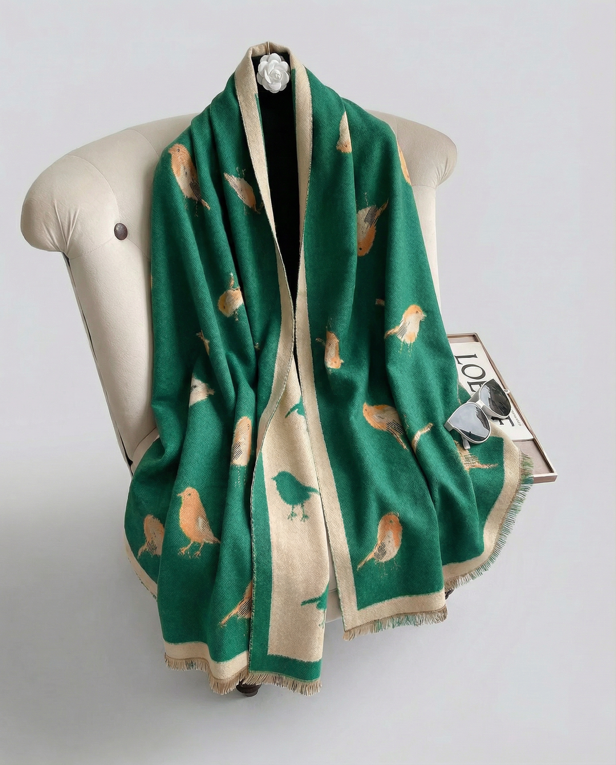 Green wrap with bird pattern draped over a mannequin on a white background