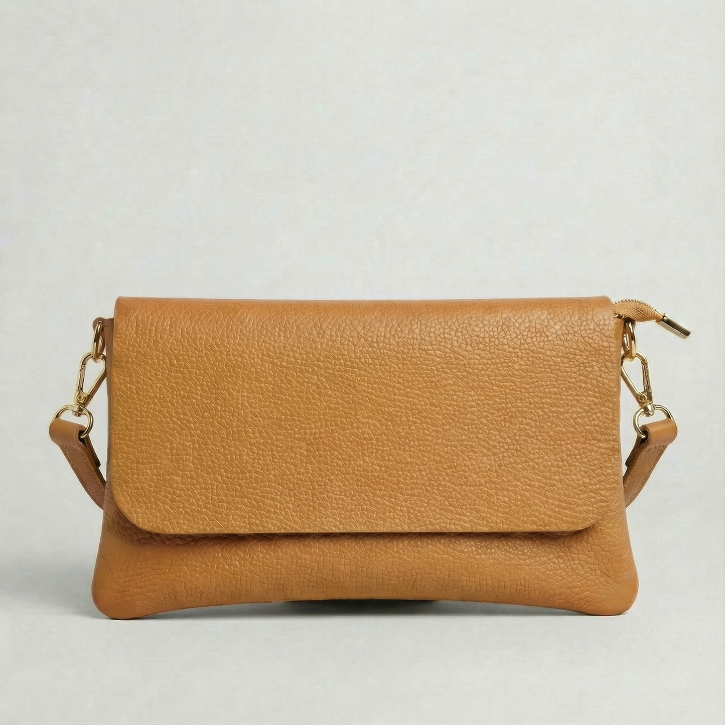 Camel pebble leather crossbody bag with a matching color adjustable strap, displayed on a light gray background.