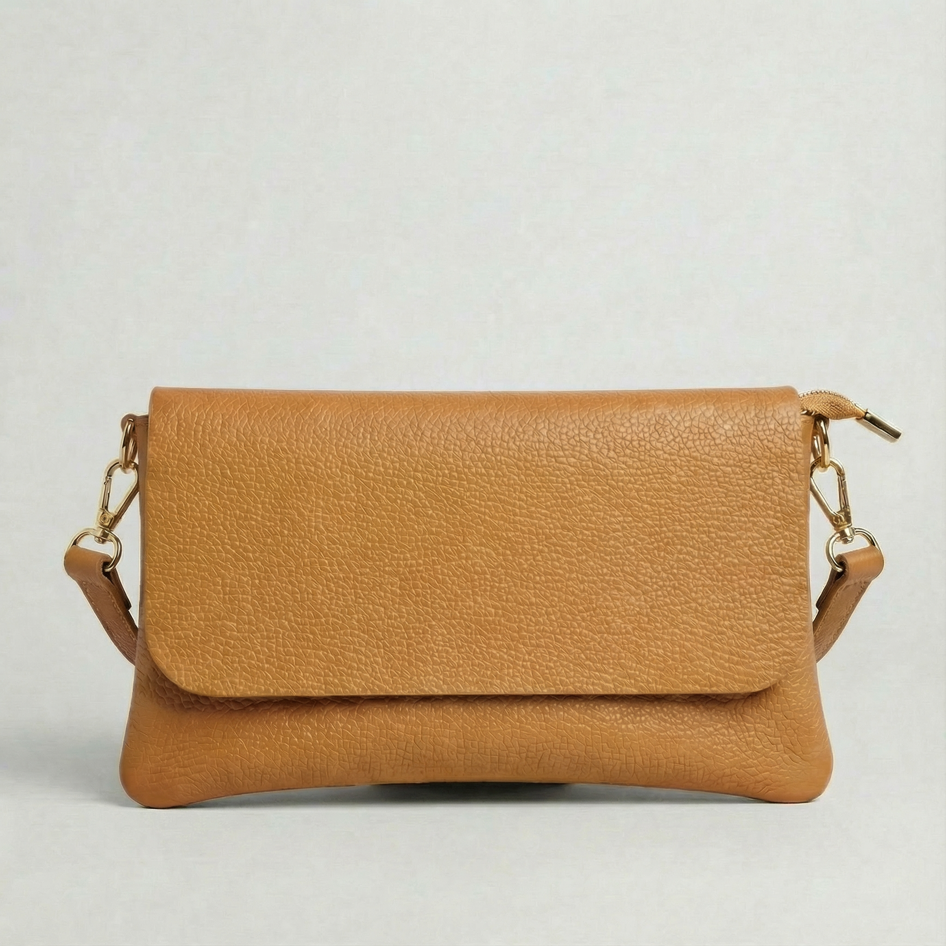 Camel pebble leather crossbody bag with a matching color adjustable strap, displayed on a light gray background.