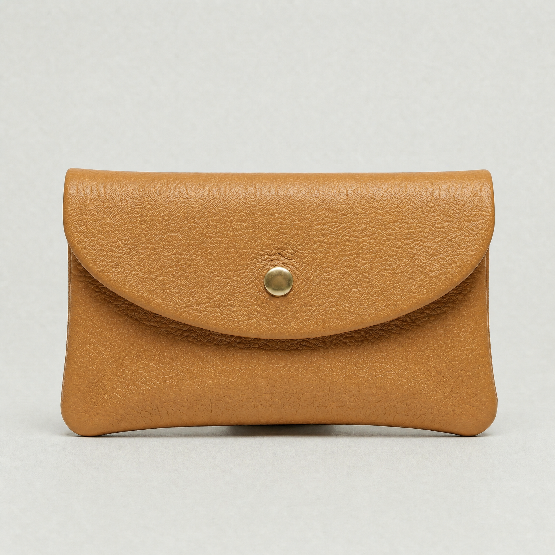 Camel leather wallet with a gold button on a light gray background