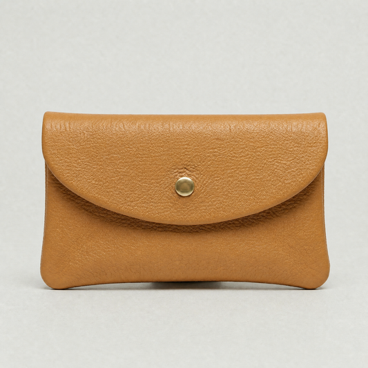 Camel leather wallet with a gold button on a light gray background
