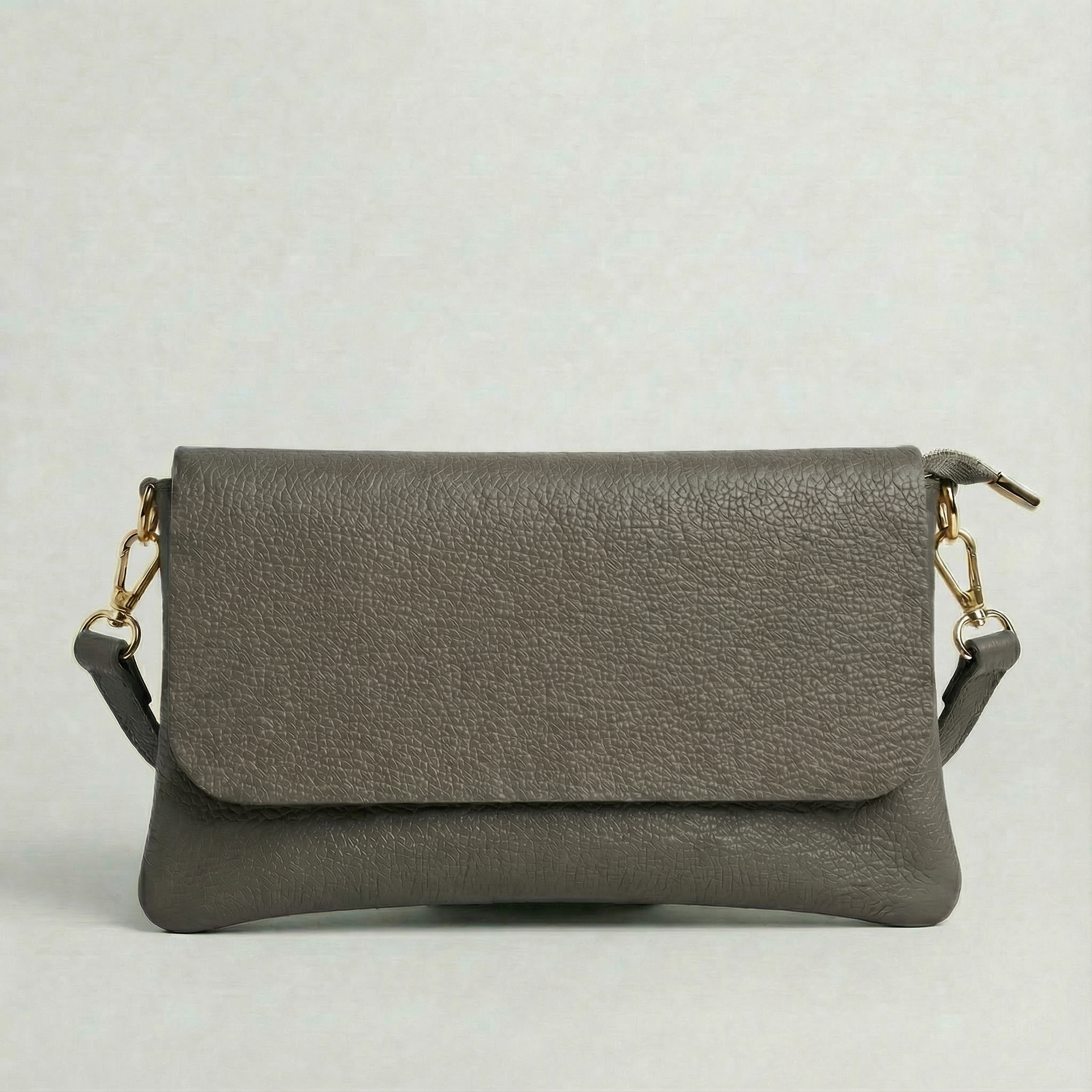 Cement pebble leather crossbody bag with a matching color adjustable strap, displayed on a light gray background.