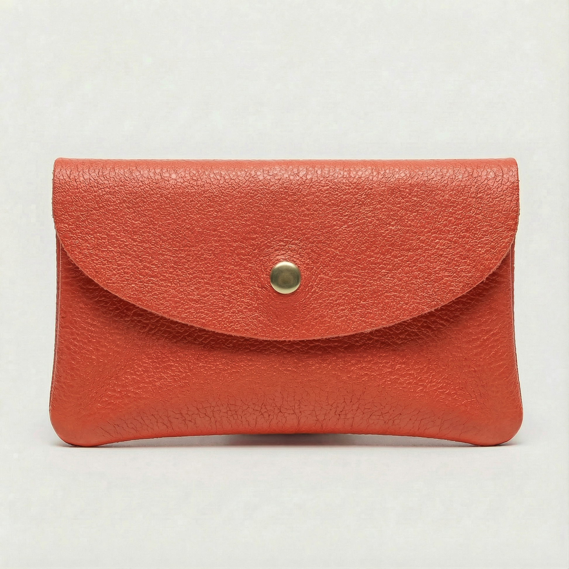 Coral pebble leather coin wallet with snap closure, minimalist Italian design, compact and elegant everyday accessory.