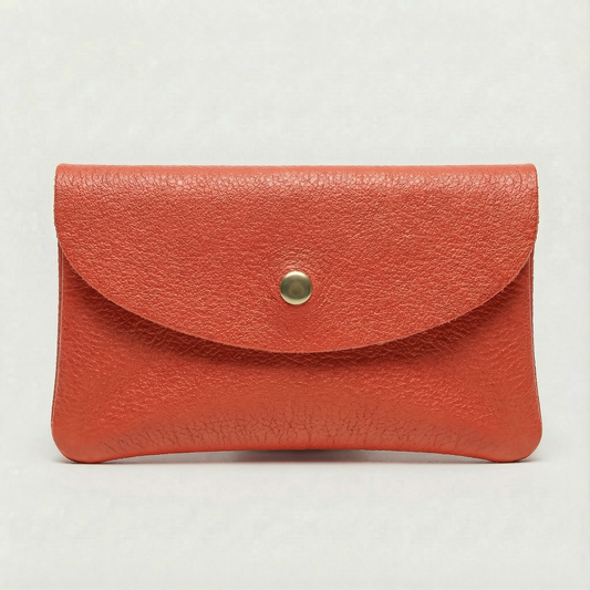 Coral pebble leather coin wallet with snap closure, minimalist Italian design, compact and elegant everyday accessory.
