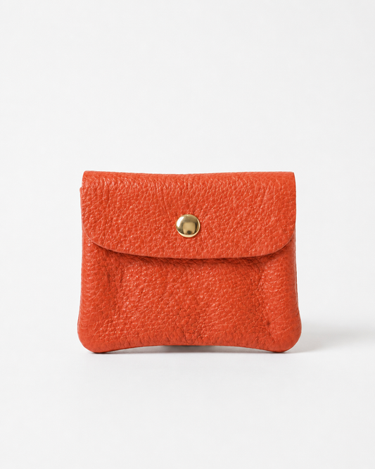 Coral pebble leather mini coin wallet with snap closure, compact Italian‑made design for coins and small essentials
