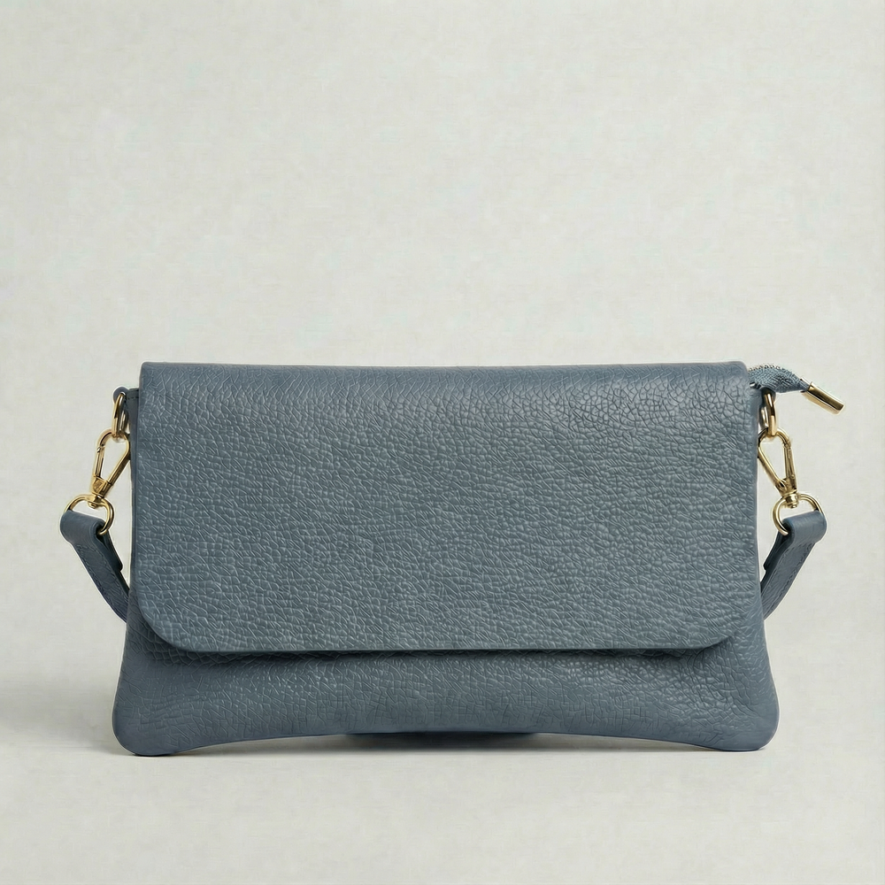 Denim pebble leather crossbody bag with a matching color adjustable strap, displayed on a light gray background.
