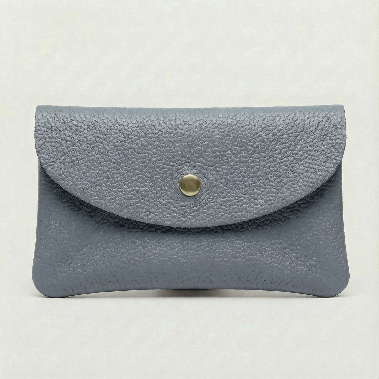 Denim pebble leather coin wallet with snap closure, minimalist Italian design, compact and elegant everyday accessory.