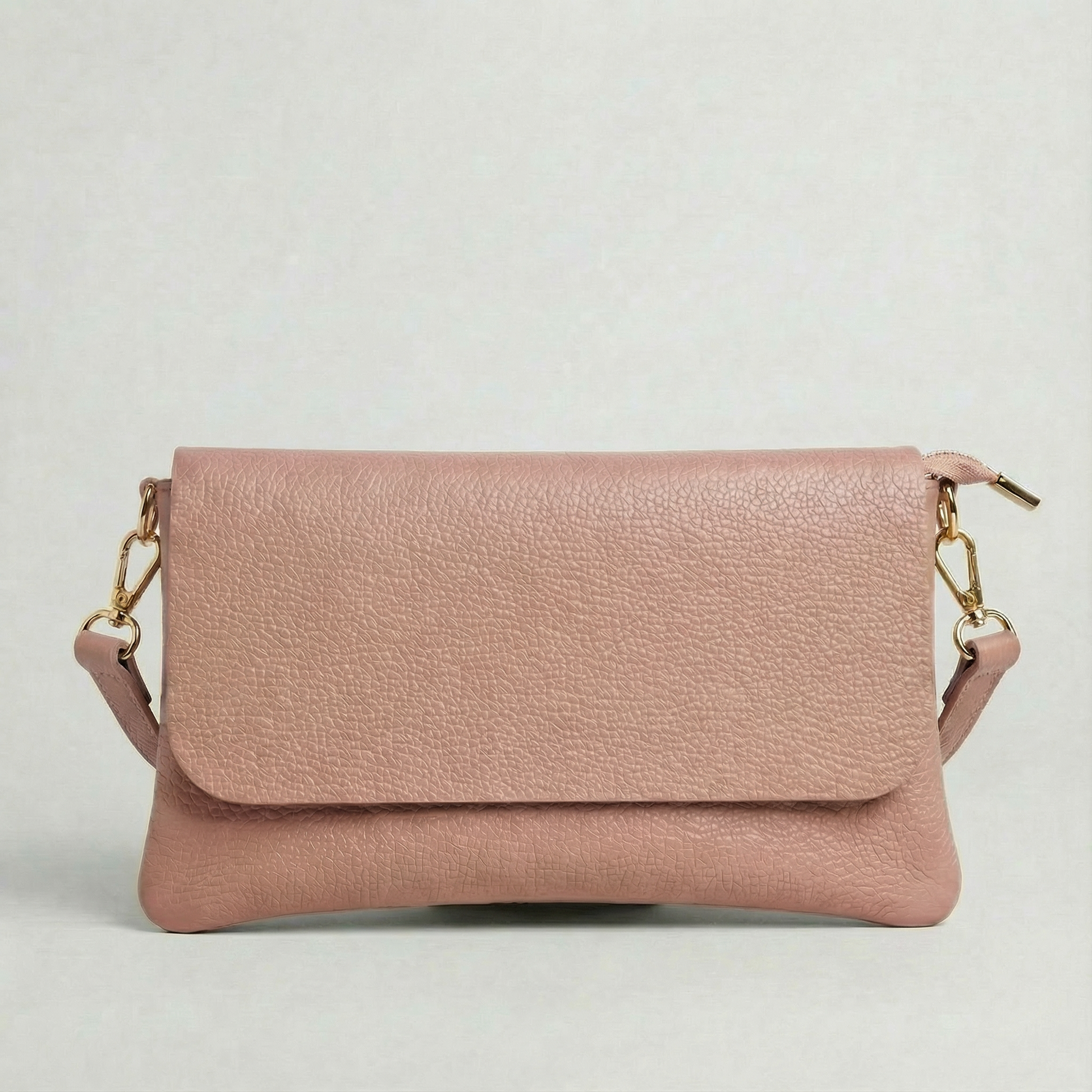 Dusty Rose pebble leather crossbody bag with a matching color adjustable strap, displayed on a light gray background.