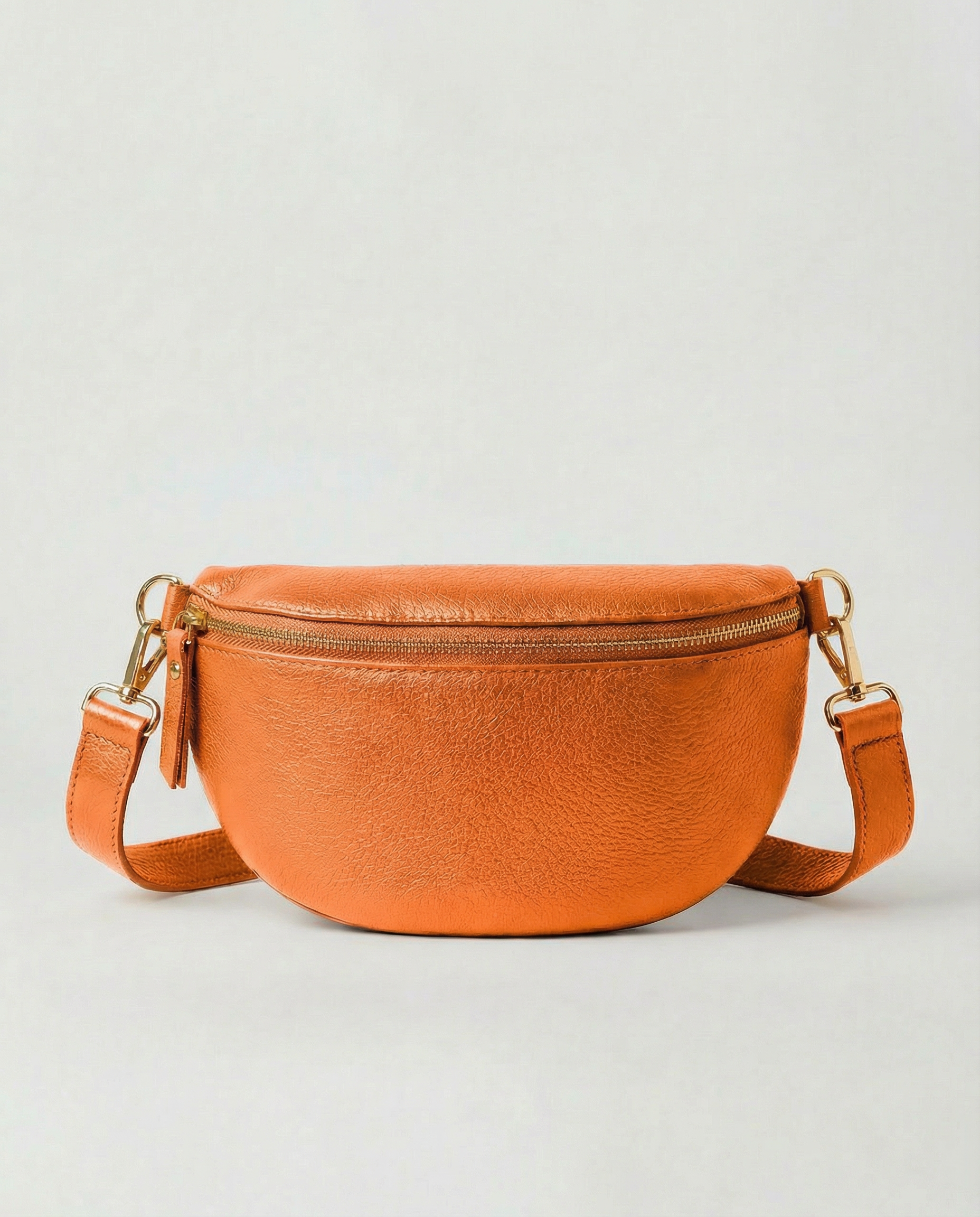 Metallic leather fanny bag in orange with adjustable strap and sleek, compact silhouette designed for hands‑free everyday wear.