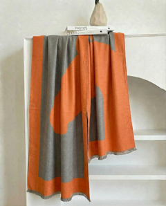 Orange and eucalyptus wrap draped over a bookshelf, view 2