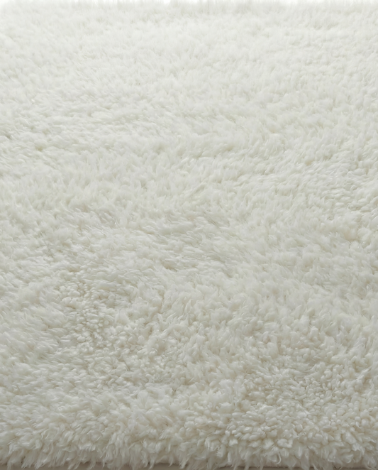 Close-up of a fluffy white rug on a light background