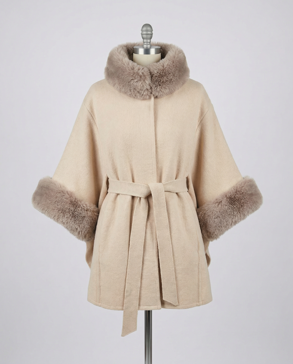 Beige Janelle coat with mocha fur trim on a mannequin against a gray background.