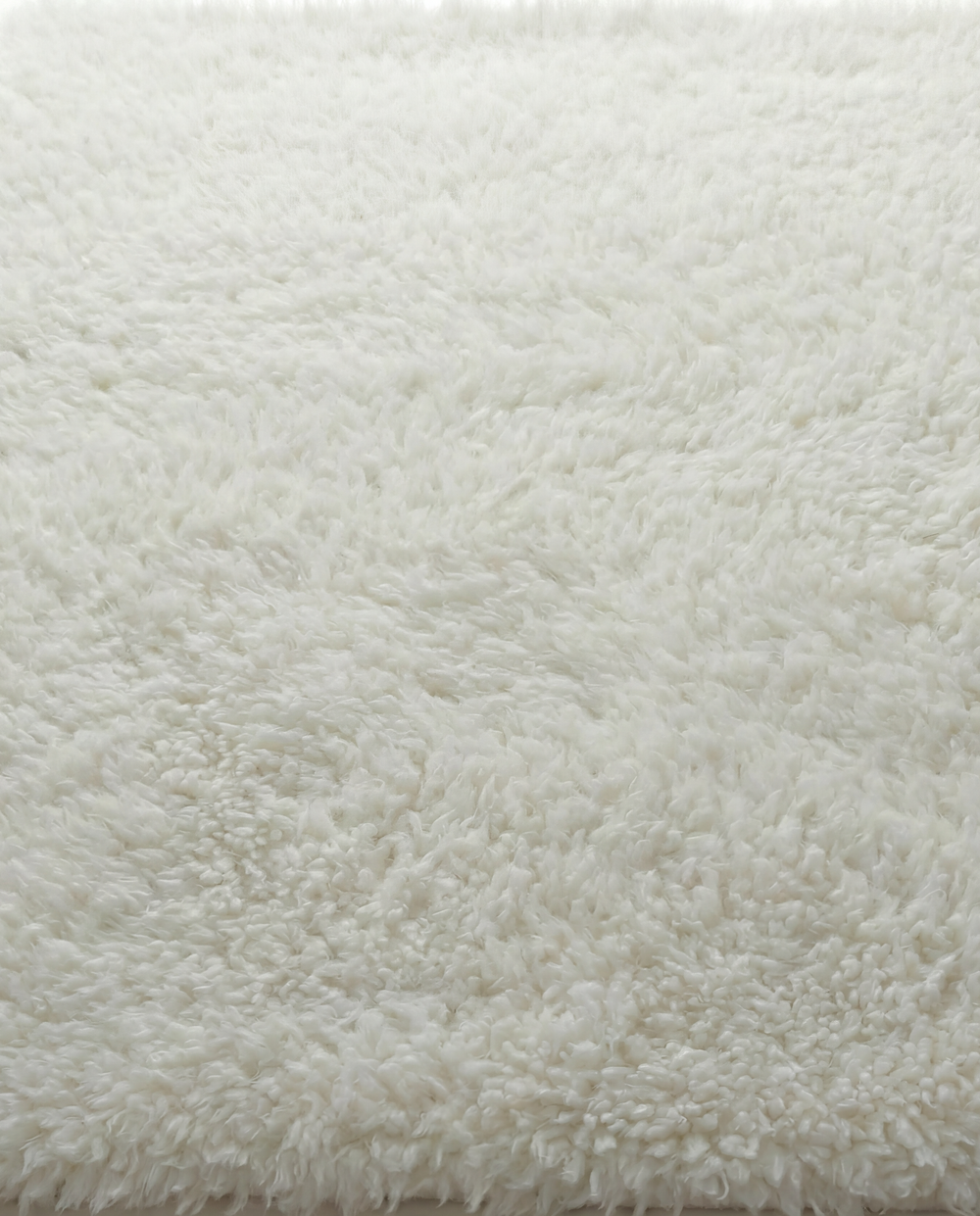 Lamb’s Wool Throw in Ivory with a soft, natural wool texture.