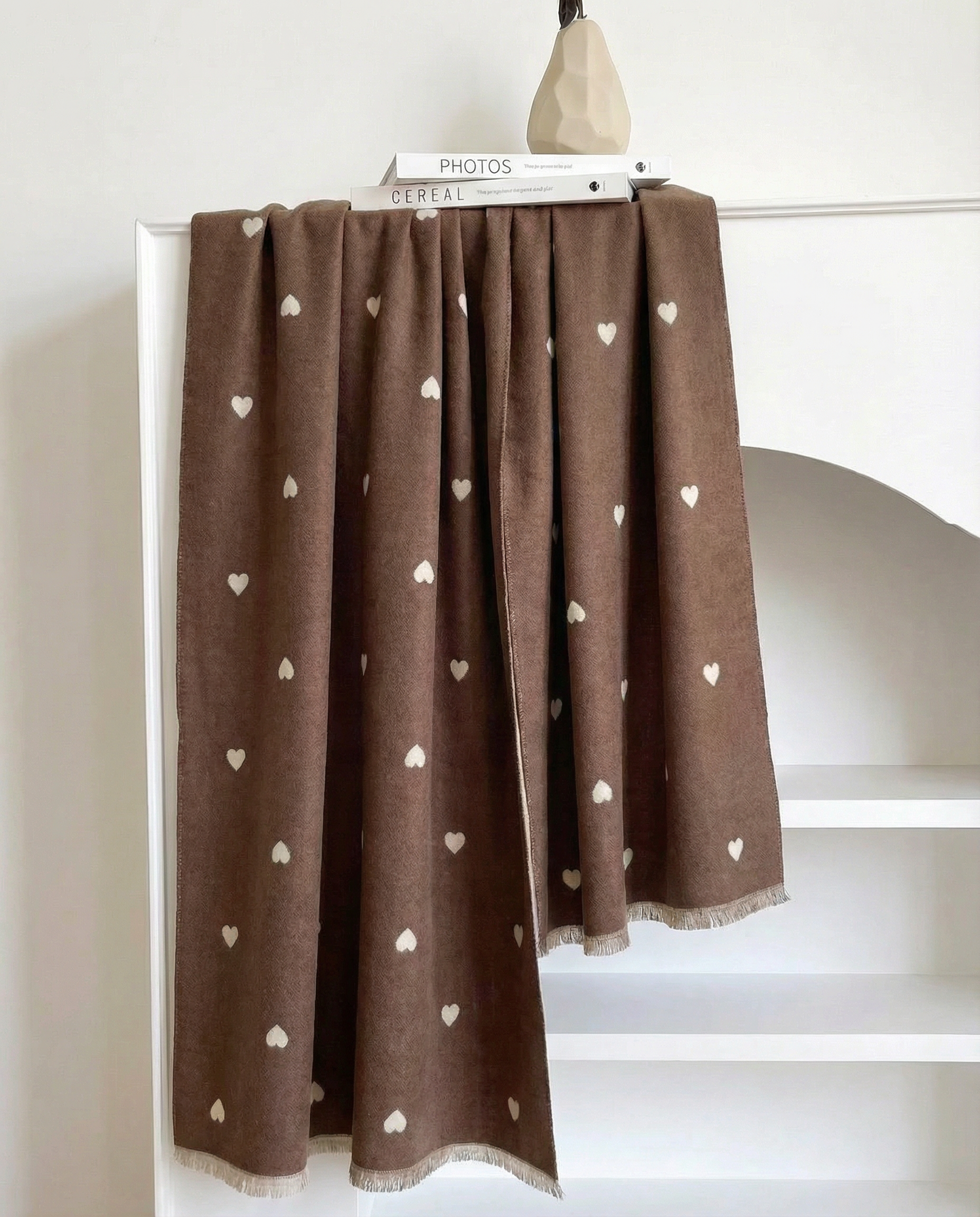 Brown wrap with white heart patterns draped over a white surface