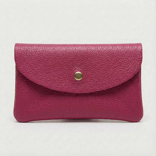 Magenta pebble leather coin wallet with snap closure, minimalist Italian design, compact and elegant everyday accessory.