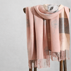 Pink wrap with fringe on a wooden stand against a light gray background, view 2