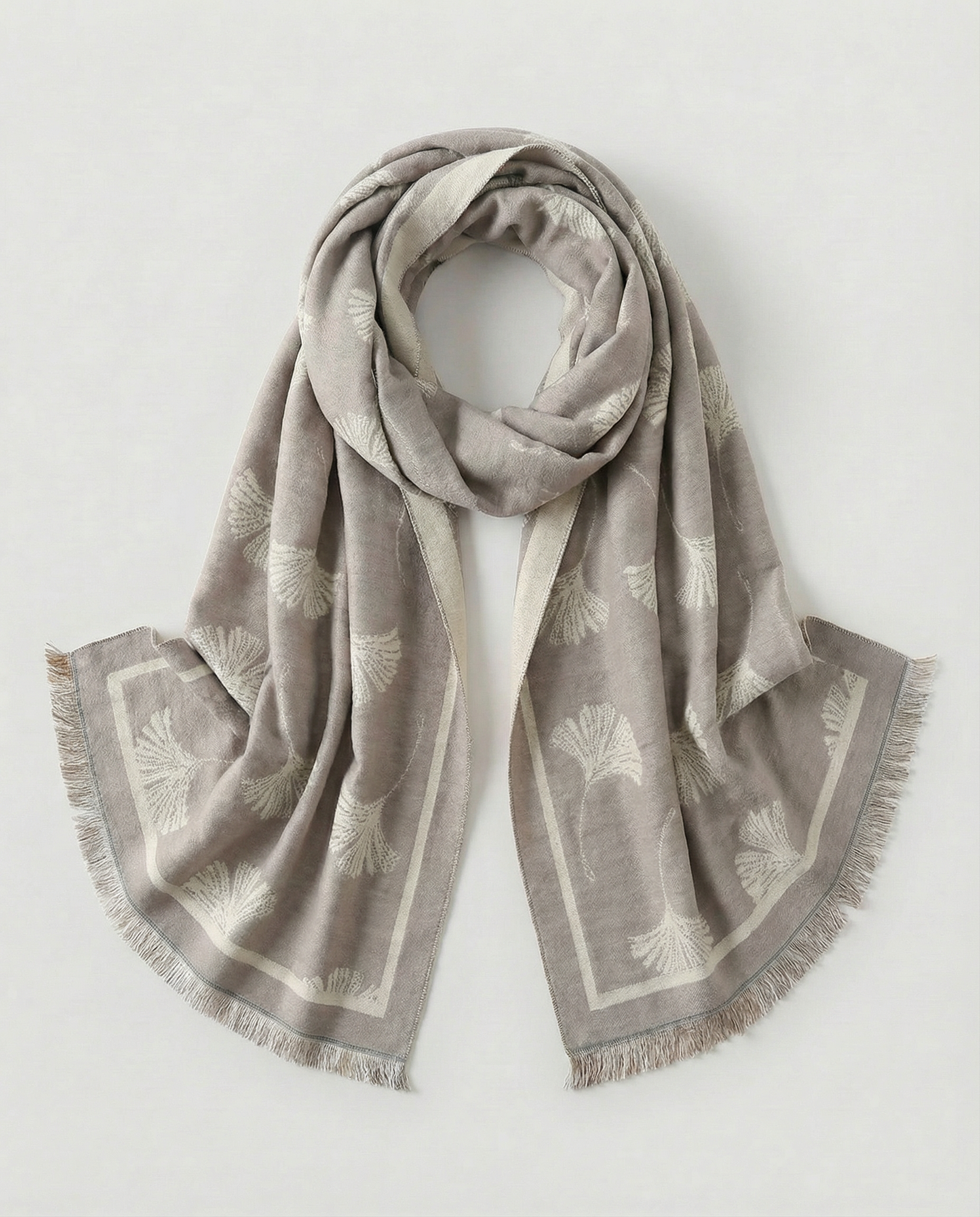 White patterned scarf with fringes on a light grey background