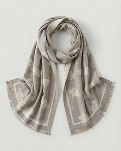 White patterned scarf with fringes on a light grey background, view 1