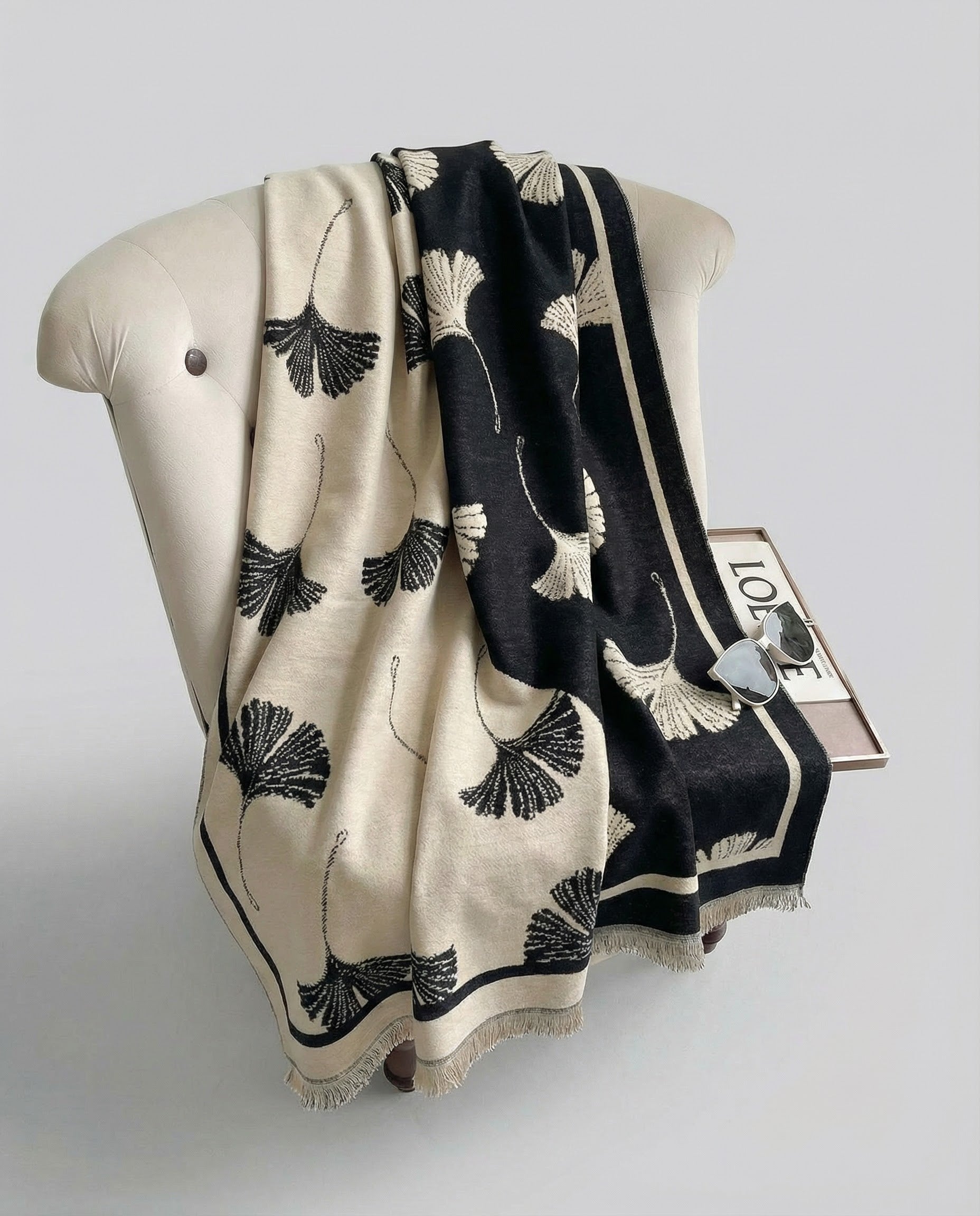 Black and beige patterned wrap draped on a chair on a light gray background.