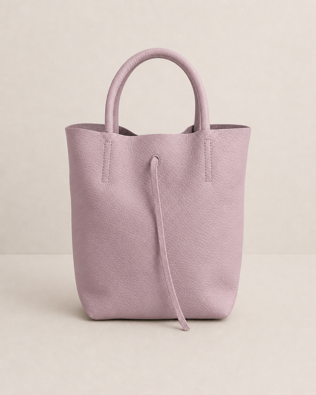 Lilac pebble leather mini tote with structured silhouette, detachable crossbody strap, compact interior, and genuine Italian craftsmanship.