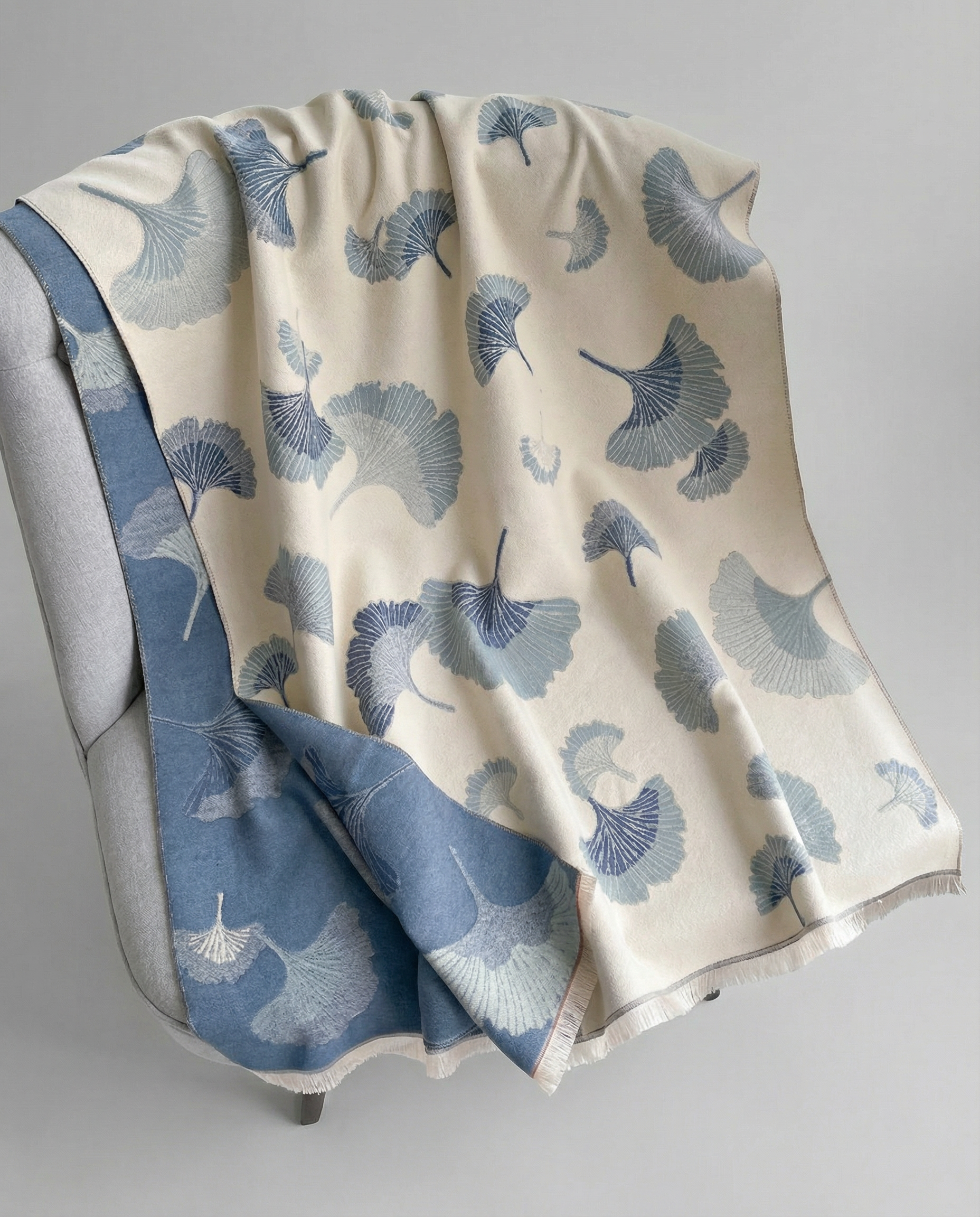 Wrap with blue floral pattern draped over a chair on a gray background