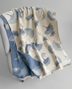 Wrap with blue floral pattern draped over a chair on a gray background, view 2