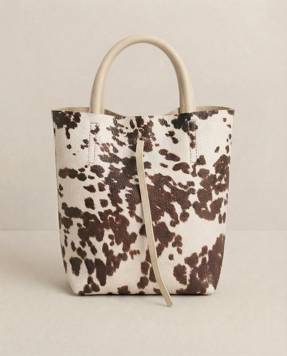 Cow pebble leather mini tote with structured silhouette, detachable crossbody strap, compact interior, and genuine Italian craftsmanship.
